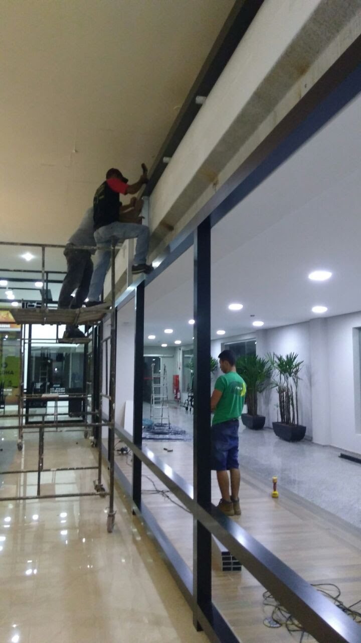 Equipe em instalação de fechamento de vidro